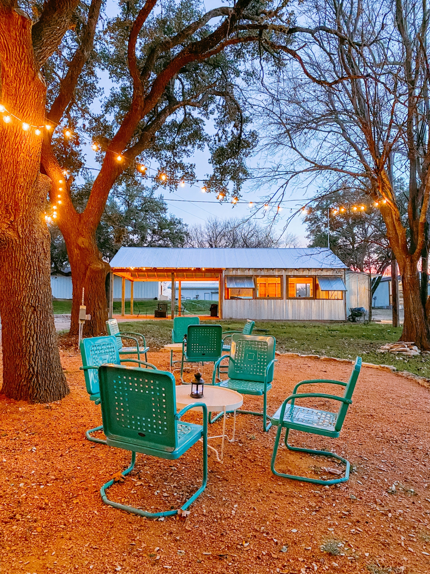 String-lit patio with vintage teal chairs